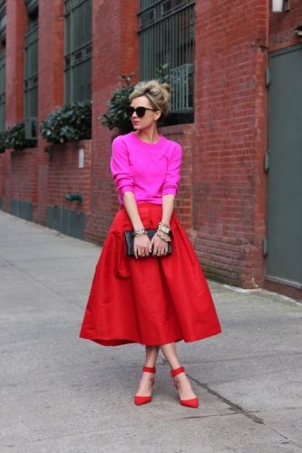 Mulher usa look de cores análogas rosa e vermelho