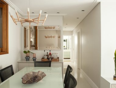 Clara e iluminada, a sala de jantar desse projeto da Tesak Arquitetura se integra com o estar e com a cozinha, através do passa pratos. Foto: Luis Gomes
