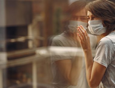 Woman in mask. Coronavirus theme. Lady by the window.